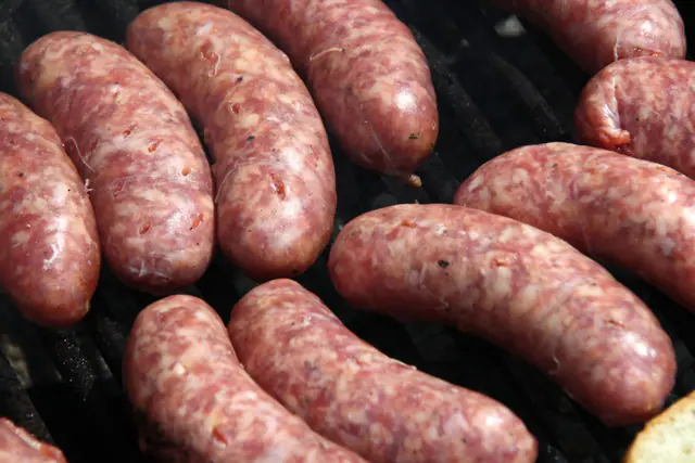Raakoja porsaanmakkaroita vierekkäin grillin ritilällä