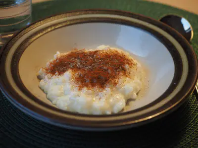 Riisipuuroa syvällä lautasella, päällä kanelia ja sokeria