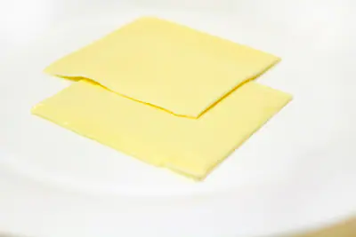 Kaksi sulatejuustoviipaletta valkoisella lautasella