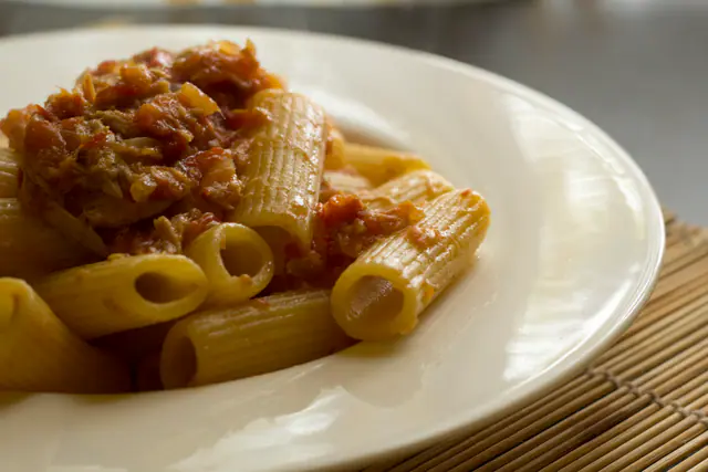 Rigatonipastaa tonnikala-tomaattikastikkeella valkoisella lautasella